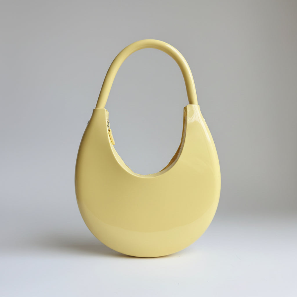 Yellow handbag held by a person with a neutral background