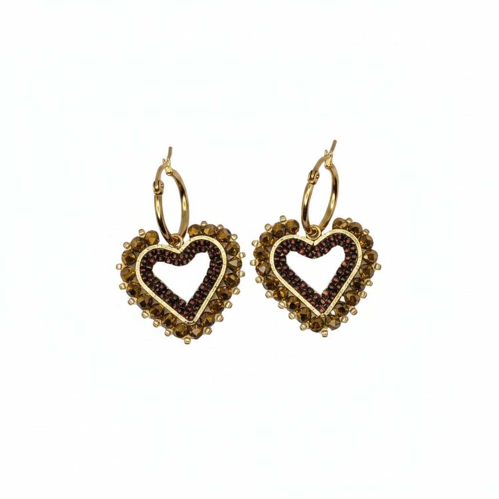 A pair of gold-toned heart-shaped hoop earrings with a smaller heart cutout in the center of each, accented with small dark brown stones, shown on a plain light gray background.