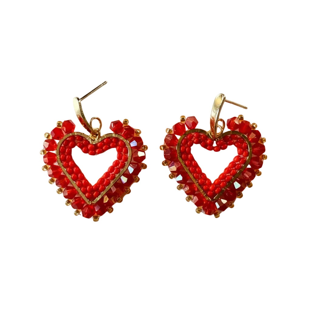A pair of handmade heart-shaped dangle earrings made from red seed beads, clear faceted rhinestones, and gold-tone metal findings, displayed on a plain light background.