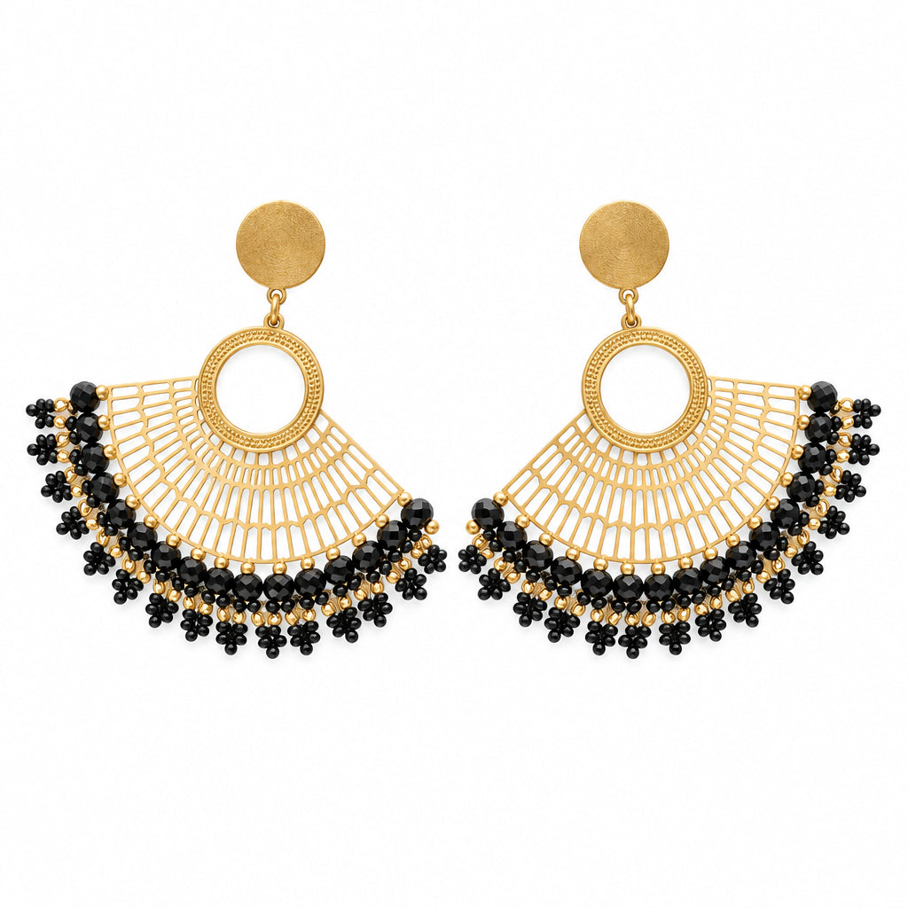 A pair of gold-toned statement earrings with circular hoops and dangling fan-shaped fringe, finished with black bead accents, displayed on a clear card against a white background.
