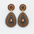 A pair of ornate teardrop dangle earrings with dark gray beaded borders, copper-toned accents, and a central rose gold teardrop, displayed on a white background.