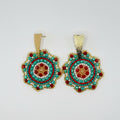 A pair of handmade beaded earrings with gold-tone metal frames and posts, featuring intricate circular beadwork in turquoise, red, white, and gold.