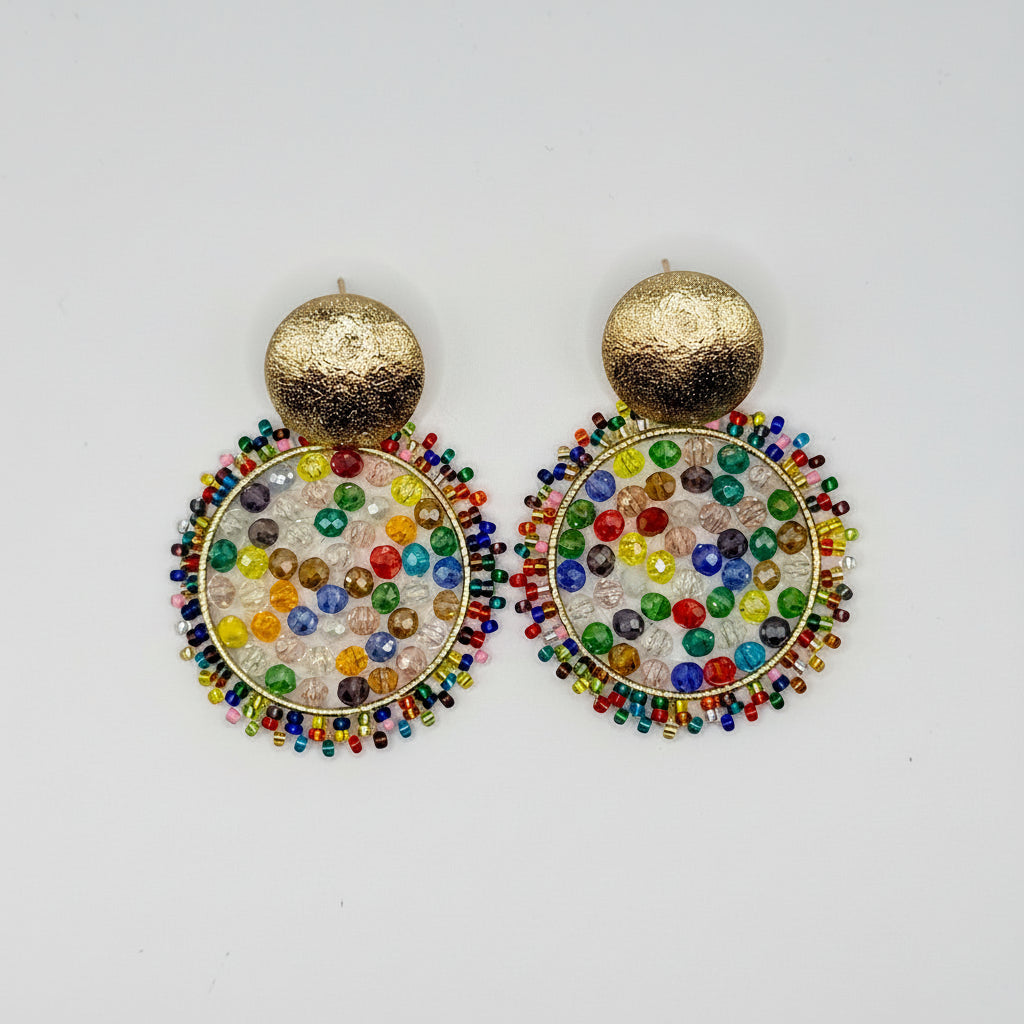 A pair of gold-tone statement earrings with textured round studs and circular dangling charms covered in multicolored seed beads, shown on a plain light gray background.