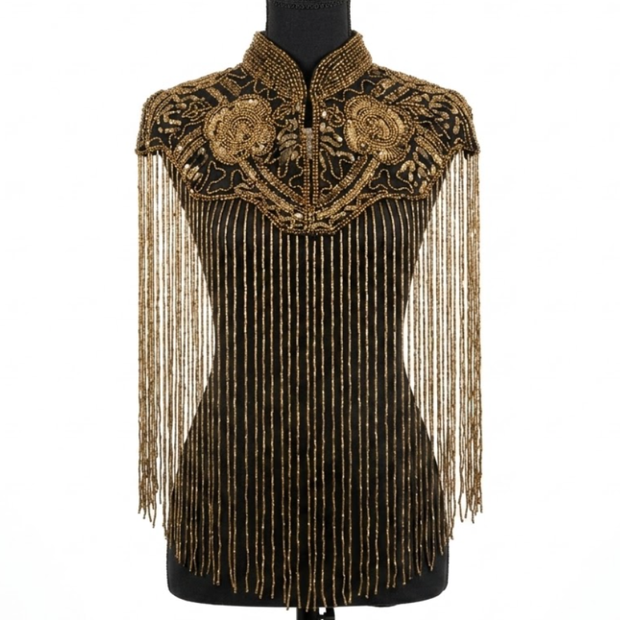 Decorative top with gold embroidery and fringe on a mannequin against a white background