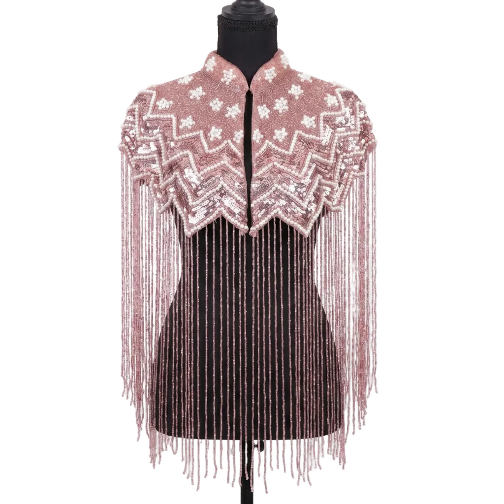Mannequin wearing a pink beaded and fringed top on a white background