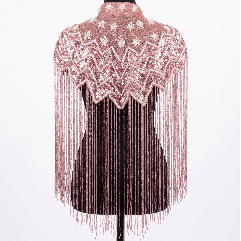 Mannequin wearing a pink beaded and fringed top on a white background
