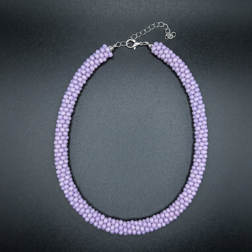 Purple beaded necklace on a dark surface