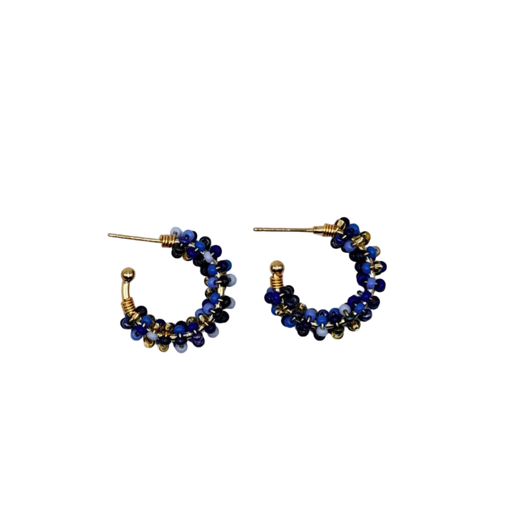 A pair of small gold hoop earrings adorned with dark blue beads, displayed on a clean white background.