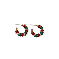 A pair of small beaded hoop earrings with red, teal, and white beads on a plain white background.
