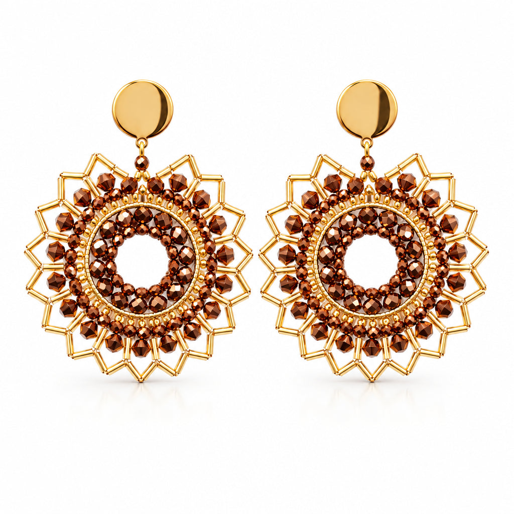 A pair of gold-toned circular drop earrings with intricate filigree cutouts and small dark brown bead accents, displayed on a white backing card against a white background.