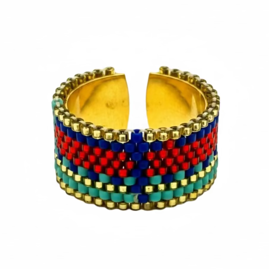 Multicolored beaded cuff bracelet with gold accents on a white background