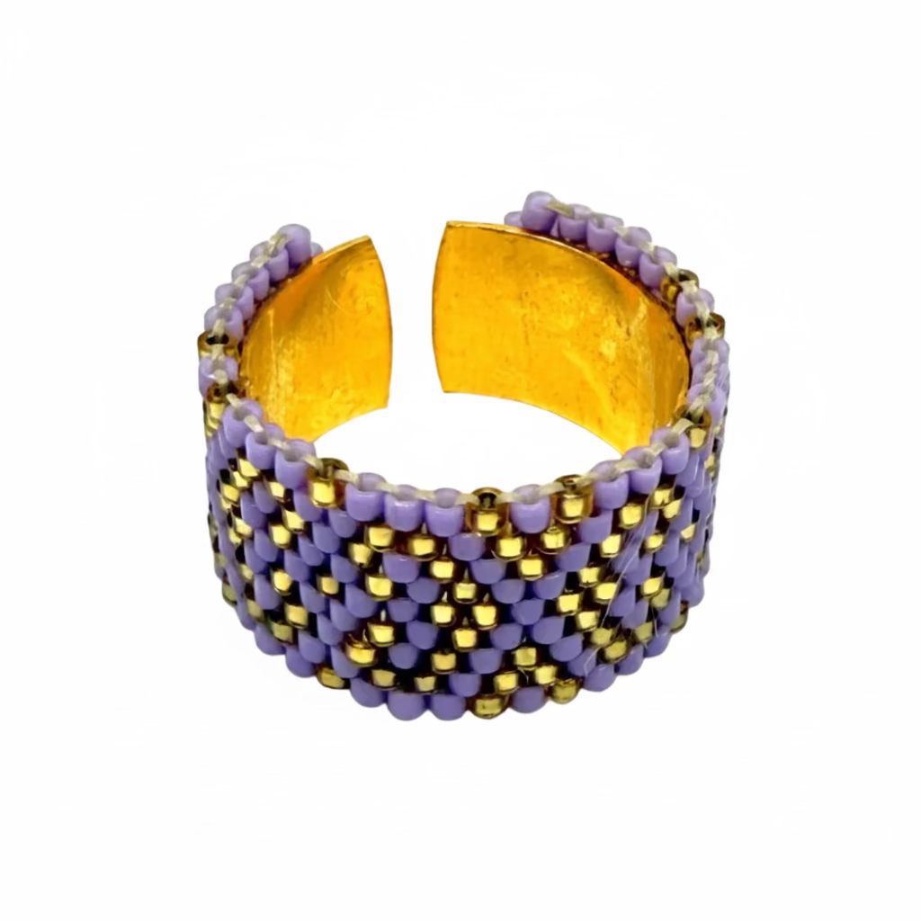 Beaded ring with purple and gold pattern on a white background