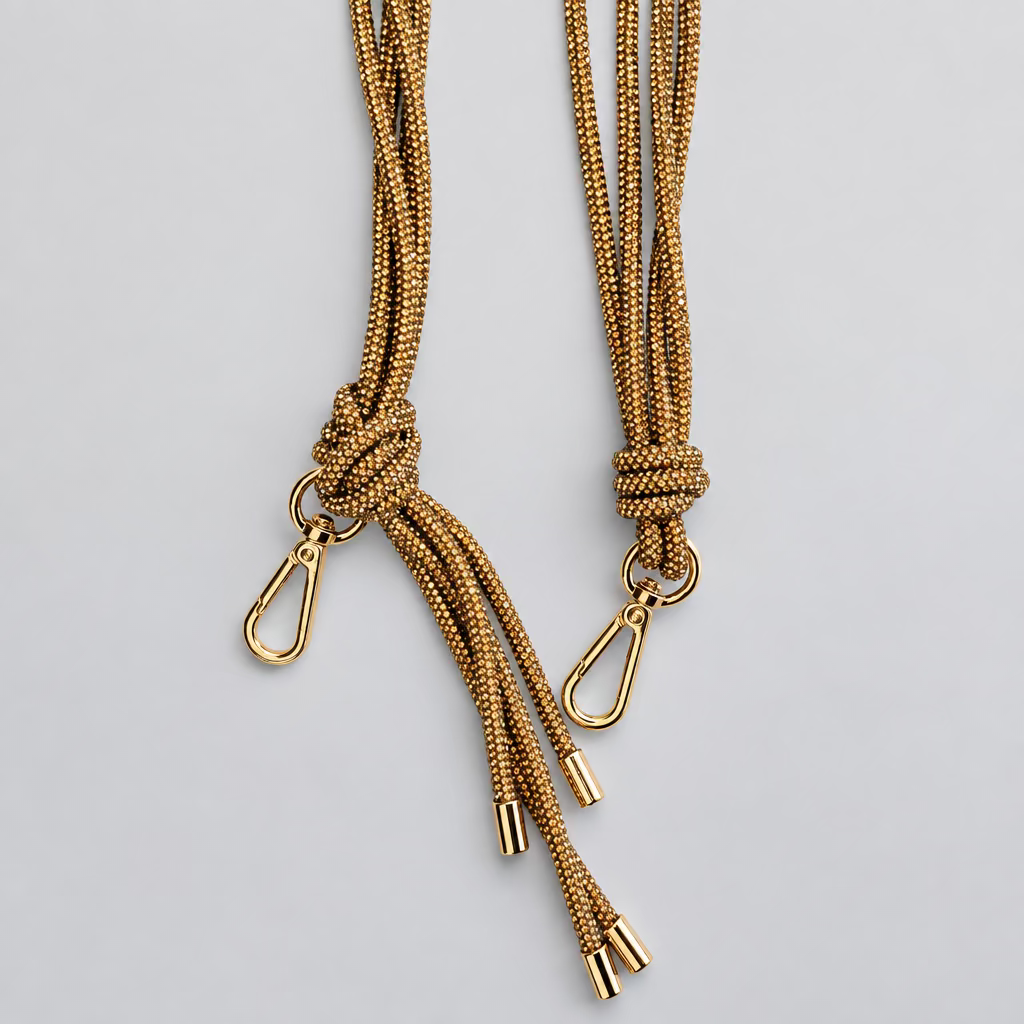 Two tan woven rope straps with brass-colored metal swivel clasp ends, laid flat on a white surface.